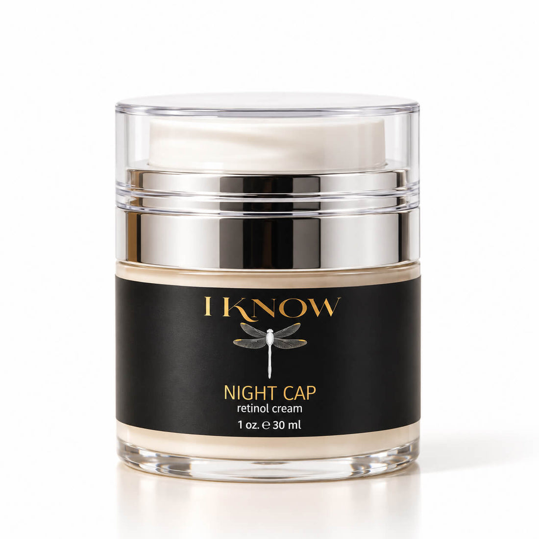 A jar of IKnow Night Cap Retinol Cream on a white background. The product is in a clear glass jar with a silver metallic collar and a black label featuring gold lettering and a dragonfly graphic.