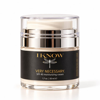 A jar of IKnow Very Necessary SPF 40 moisturizing cream with a black label, silver metallic collar, and clear cap, shown on a white background.